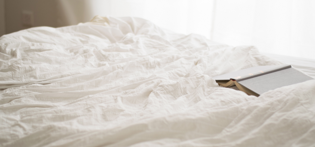 Hotel bed with open book
